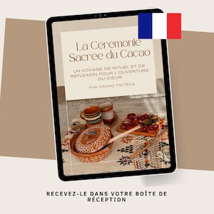 May include: A tablet displays the text "La Cérémonie Sacrée du Cacao" with additional text in French. The image shows a table setting with pottery, cups, and a tray of food. A French flag is in the upper right corner.