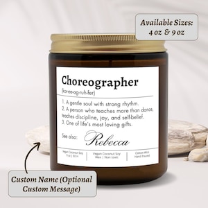 Peut inclure: Un pot de bougie en verre brun avec un couvercle doré. L'étiquette indique "Chorégraphe" avec des définitions et le nom "Rebecca". Tailles disponibles : 113 g et 255 g. La bougie est faite de cire de soja de noix de coco végétalienne et d'une mèche en coton.