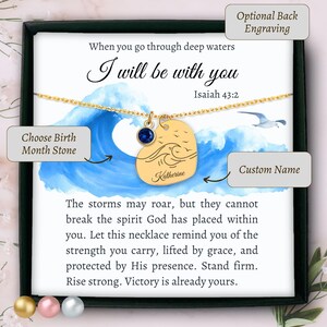 May include: A gold-tone necklace featuring a heart-shaped pendant engraved with a wave design and the name Katherine, accompanied by a small blue birthstone charm, presented on a card with the text When you go through deep waters I will be with you Isaiah 43:2.