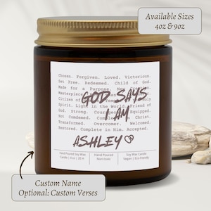 Könnte beinhalten: Ein braunes Glas-Kerzenglas mit goldenem Deckel. Das Etikett lautet "GOD SAYS I AM" mit Affirmationen und dem Namen "ASHLEY". Erhältlich in 113g und 255g Größen. Benutzerdefinierter Name und Verse sind optional.