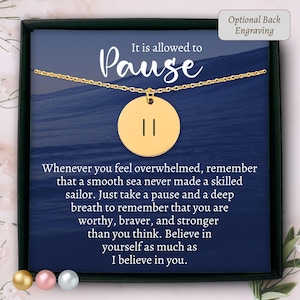 May include: A gold-toned circular pendant necklace featuring a pause symbol, presented on a dark blue card with the text It is allowed to Pause and a motivational quote about feeling overwhelmed, plus an Optional Back Engraving label.