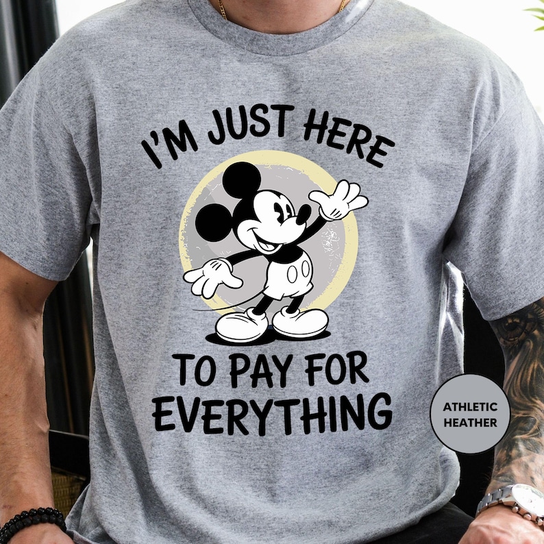 a man wearing a mickey mouse t - shirt