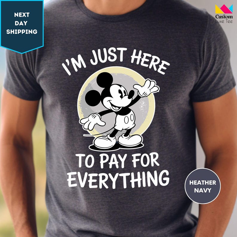 a man wearing a mickey mouse t - shirt that says i'm just here