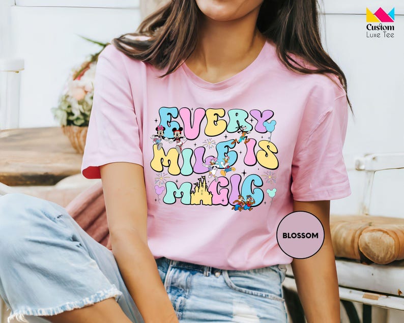 a woman wearing a pink t - shirt that says every mile's magic is