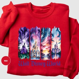 A red sweatshirt with a graphic design featuring four different castle scenes and fireworks.