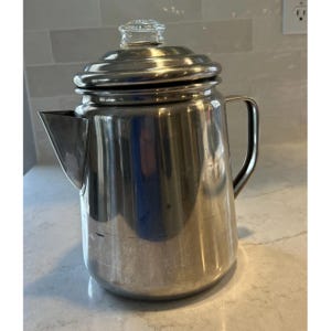 Cafeteira Coleman de aço inoxidável com percolação para 12 xícaras, ideal para fogão, camping e atividades ao ar livre.