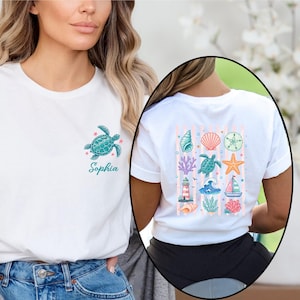 May include: A white short-sleeve t-shirt featuring a small teal sea turtle graphic and the name Sophia on the front left chest. The back displays a grid of nautical illustrations including shells, a starfish, a lighthouse, and a sailboat.