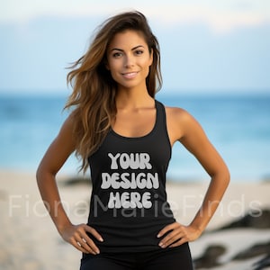 Puede incluir: Camiseta sin mangas negra con el texto blanco "YOUR DESIGN HERE". La camiseta sin mangas la lleva una persona. El fondo muestra una escena de playa con el mar al fondo. Una camiseta sencilla y versátil para diversas actividades.