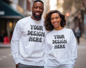 May include: A couple wearing white sweatshirts with the text "YOUR DESIGN HERE" in black. They are standing in an urban setting.
