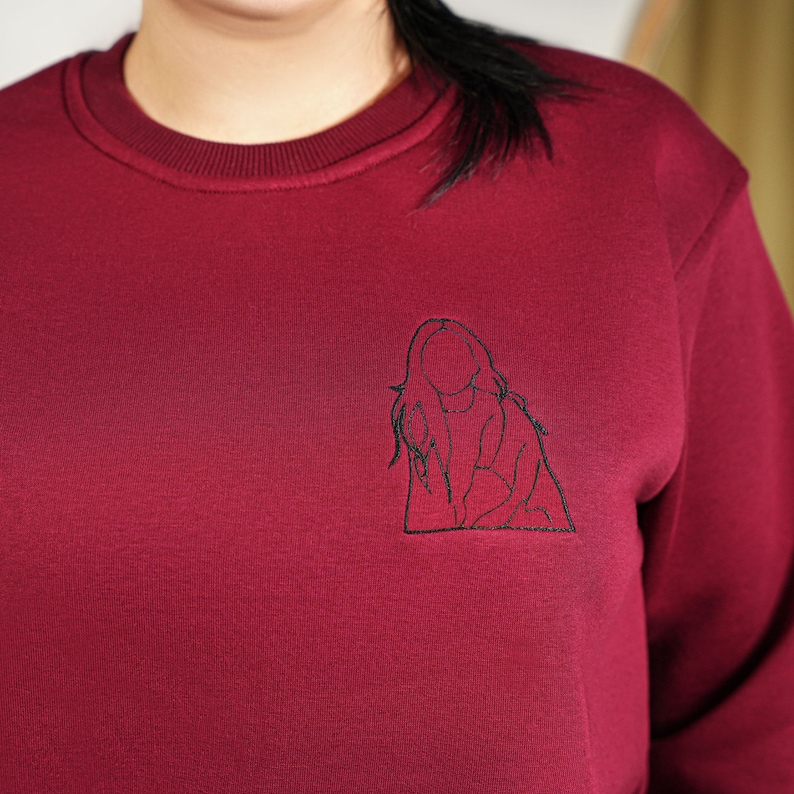 a woman wearing a red sweater with a picture of a dog on it