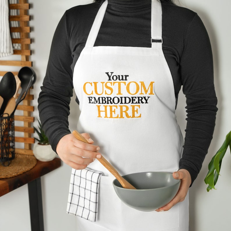 a woman wearing an apron holding a bowl and wooden spoon
