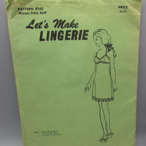 May include: A green sewing pattern for a full slip, with a line drawing of a woman wearing the slip. The pattern is titled "Let's Make Lingerie" and is numbered 145. The price is $1.00.