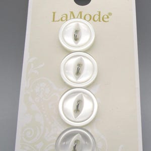 May include: A card of four white LaMode buttons, style 1483, arranged vertically. Each round button features a central, elongated, eye-shaped indentation with a single shank attachment point. The packaging includes the text LaMode, 1483, and 4716.