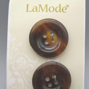 May include: Two brown and amber LaMode buttons with four holes each, attached to a cream-colored card. The card has a decorative floral pattern and the text "LaMode" and "Style 29407".