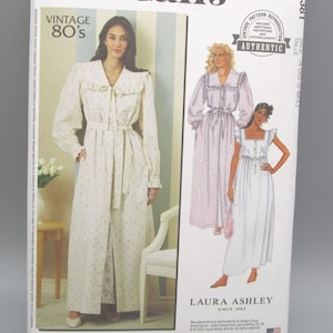 May include: A McCall's sewing pattern for a vintage 80s Laura Ashley design. The pattern features illustrations of long dresses and robes. The package is white with text and illustrations in black and other colors.