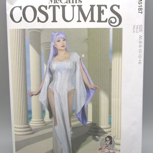 May include: McCall's Costumes pattern envelope featuring a woman in a fantasy costume. The costume is white with blue accents and includes a long flowing skirt and cape. The envelope has the text "COSTUMES" in large letters.