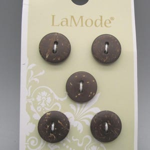 May include: A package of five round coconut buttons. The buttons are dark brown with a natural, textured appearance and two holes for sewing. The card has the LaMode logo and the text "Coconut / Noix de Coco / Coco".