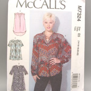 May include: A McCall's sewing pattern envelope featuring a woman wearing a patterned blouse. The envelope displays illustrations of various blouse styles, including a sleeveless pink top, a short-sleeved blue top, and a long-sleeved patterned blouse. The pattern size is E5 (14-16-18-20-22).