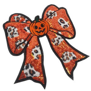 Op de afbeelding: Een Halloween-strik met een oranje paillettenachtergrond en zwarte rand. De strik heeft een luipaardprintpatroon en een pompoen in het midden. Perfect voor Halloween-decoraties en knutselen.