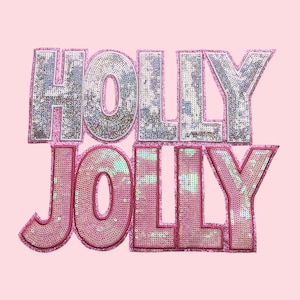 Puede incluir: Fondo rosa con las palabras "HOLLY JOLLY" en letras con lentejuelas. La palabra superior es plateada con un contorno rosa, y la palabra inferior es rosa con un contorno rosa más oscuro. Las letras son grandes y en negrita.