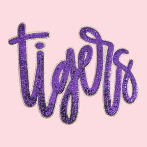 May include: The word "Tigers" in a cursive font, rendered in purple sequins with a gold outline, is displayed on a light pink background. The design is simple and eye-catching.