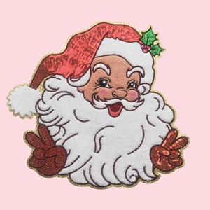 May include: Embroidered Santa Claus patch with a red sequined hat and peace signs. The Santa has a white beard and a smiling face with rosy cheeks. A sprig of holly is on the hat, and the patch is outlined in gold.