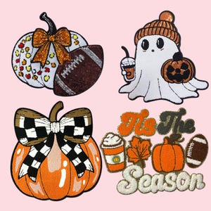 Op de afbeelding: Vier geborduurde patches met een herfstthema. Inclusief een pompoen met een strik en een voetbal, een spook met een pompoen en koffie, en een oranje pompoen met een geblokte strik. De laatste patch zegt "It's The Season".