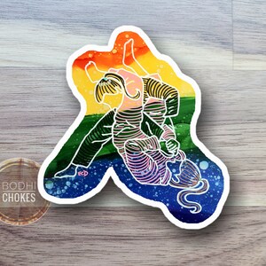 May include: A sticker with a line drawing of two people in a wrestling hold. The drawing is on a background of a rainbow flag with a white outline.