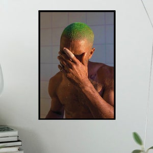 Può includere: Un ritratto ravvicinato di un uomo con i capelli verdi, che si copre il viso con la mano. Lo sfondo è una parete di un bagno piastrellata.