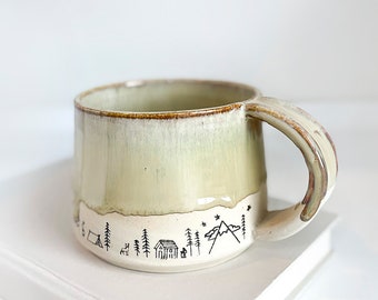 handmade ceramic camping/outdoor images around base, creamy tan color top and no glaze on the bottom