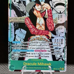 May include: Trading card featuring Dracule Mihawk from "One Piece." The card has a green background with Japanese text and a character illustration. The card displays the number 10000 and has English text describing the character's abilities.