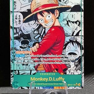 Puede incluir: Carta coleccionable con Monkey D. Luffy de la serie One Piece. La carta tiene un borde verde y presenta a Luffy sonriendo con una camisa roja y un sombrero de paja. La carta incluye texto japonés e instrucciones del juego.