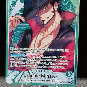 May include: A trading card featuring Dracule Mihawk from the One Piece series. The card has a green background with a character illustration in a black hat and red accents. The card text includes game instructions and a power rating of 5000.