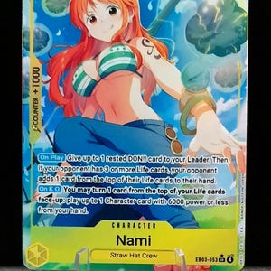 Könnte beinhalten: Eine Sammelkarte mit der Figur Nami von der Strohhut-Crew. Die Karte hat ein lebendiges Design mit einem Porträt von Nami, einer Figur aus dem Anime One Piece, und Spielanweisungen. Die Karte wird in einem transparenten Kunststoffständer gehalten.