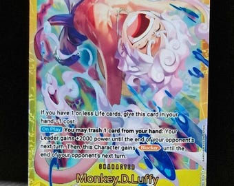 Peut inclure: Carte à collectionner avec une illustration colorée d'un personnage aux cheveux blancs et au haut rouge. Le numéro 10 est en haut à gauche et 12000 en haut à droite. Le personnage s'appelle Monkey.D.Luffy.