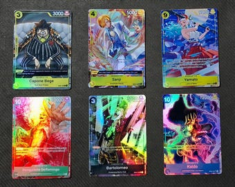 Puede incluir: Un conjunto de diez cartas coleccionables con personajes del anime One Piece. Las cartas son holográficas y presentan ilustraciones coloridas de los personajes. Las cartas están numeradas 3, 4, 6, 10, 3, 10. Los personajes que aparecen en las cartas son Capone Bege, Sanji, Yamato, Donquixote Doflamingo, Bartolomeo y Kaido.