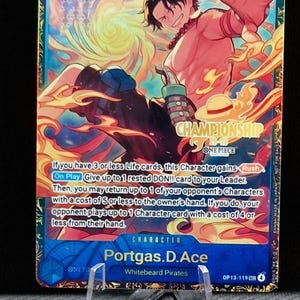 以下が含まれることがあります： ポートガス・D・エースが描かれたワンピースチャンピオンシップカード。カードは青色の背景にキャラクターイラストと炎があります。カードテキストにはゲームの説明とキャラクターの詳細が含まれています。