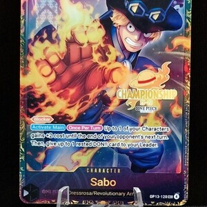 May include: A collectible trading card featuring Sabo from One Piece. The card displays Sabo with a fiery fist, a black top hat, and the text "CHAMPIONSHIP". The card has a 6 cost and 7000 power.