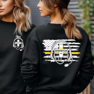 May include: Black sweatshirt with a white and yellow graphic of a headset, cross, and the word "DISPATCH". The front of the sweatshirt has the name "Alice" and a smaller headset graphic. The back has a distressed American flag design.