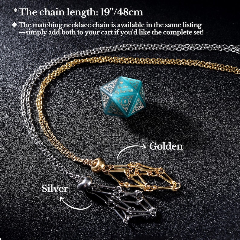 May include: A silver and gold necklace with a geometric pendant, displayed with a teal blue, multi-sided die. The chain length is 19 inches (48cm). The image is on a dark background.