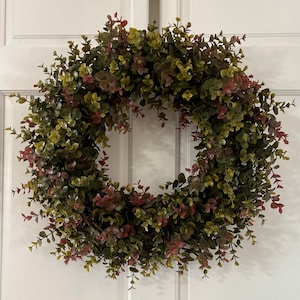 Fall green and red eucalyptus wreath. Perfect to create a cozy and welcoming home entrance for your family and friends.