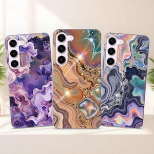 Puede incluir: Tres fundas para teléfono con diseños abstractos. Las fundas presentan patrones arremolinados en tonos de morado, naranja, dorado y azul. Cada funda tiene una matriz de cámara en la parte superior izquierda.