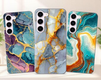 Può includere: Tre custodie per telefono con design marmorizzati. Le custodie presentano una varietà di colori, tra cui verde acqua, viola, oro, grigio e arancione. Ogni custodia ha un ritaglio per la fotocamera con tre lenti.