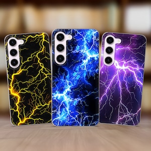 May include: Three phone cases featuring lightning bolt patterns. One case has a black background with yellow lightning, another has a blue background with blue lightning, and the third has a purple background with white lightning. Each case has a camera array.
