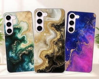 Può includere: Tre custodie per telefono con design unici. La prima custodia ha un motivo marmorizzato verde e oro. La seconda custodia presenta un design marmorizzato oro, nero e bianco. La terza custodia ha un motivo galassia blu e rosa con accenti dorati.