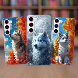 May include: Three phone cases with different designs featuring wolves. The first case has a white wolf with blue eyes on a white and gray background. The second case has a white wolf with blue eyes on a blue and white background. The third case has a brown wolf with blue eyes on a brown and orange background.