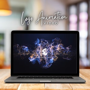 May include: A laptop computer displaying a logo animation video with a blue and gold abstract design. The logo is a white cube with the text "MARTINEZ ARENA" below it.