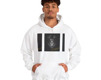 May include: White hooded sweatshirt featuring a black and white lion graphic. The lion graphic is centered on the front of the sweatshirt, with the word "FAVOUR" in gold lettering below the lion's head. The sweatshirt has a kangaroo pocket.