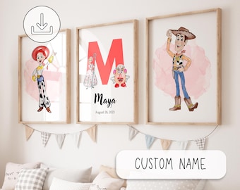 May include: Three framed prints featuring cartoon characters. One print shows a cowgirl, another has a large red letter "M" with characters and the name "Maya", and the third depicts a cowboy. The prints are in wooden frames and hang above a sofa.