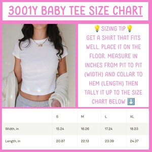 May include: A 3001Y baby tee size chart with a white t-shirt image and text instructions. The chart lists sizes S, M, L, and XL with width and length measurements in inches. The text includes a sizing tip to measure from pit to pit and collar to hem.